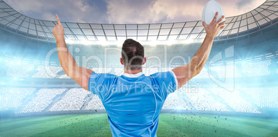 Composite image of rugby player cheering with the ball