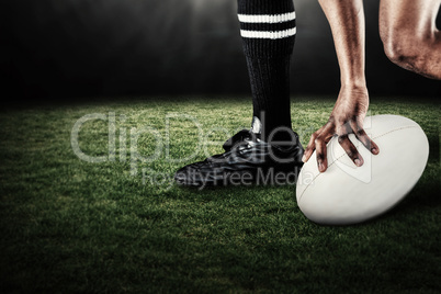 Composite image of low section of athlete holding ball while running