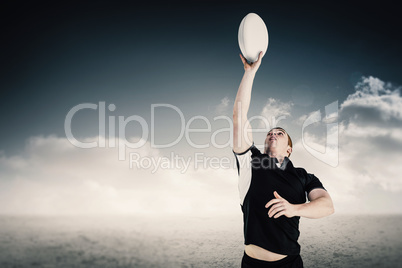 Composite image of rugby player catching a rugby ball