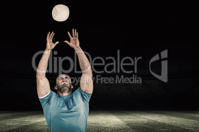 Composite image of rugby player catching the ball