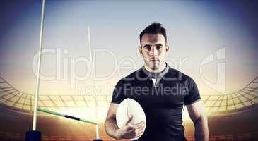 Composite image of tough rugby player holding ball