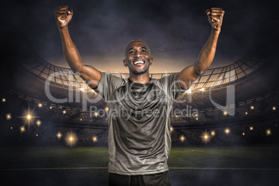 Composite image of happy sportsman with clenched fist after vict