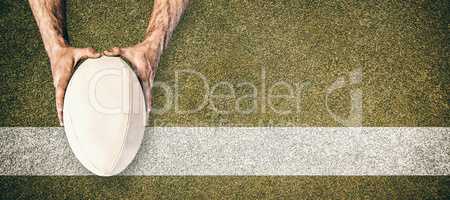 Composite image of man holding rugby ball