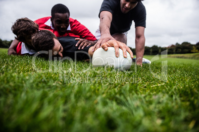 Rugby players tackling during game