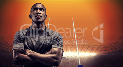 Composite image of thoughtful athlete standing with arms crossed