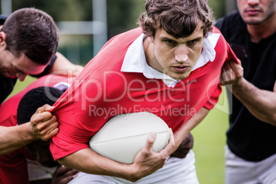 Rugby players tackling during game