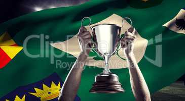 Composite image of successful rugby player holding trophy