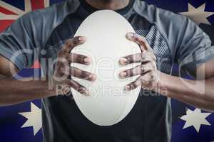 Composite image of cropped image of sportsman pressing rugby bal