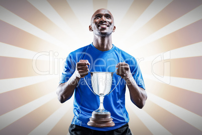 Composite image of happy athlete holding trophy looking up