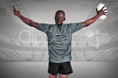 Composite image of rear view of athlete with arms raised holding