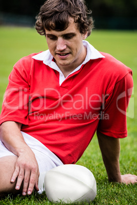 Rugby player sitting on grass before match