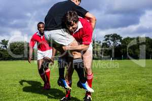 Rugby players tackling during game