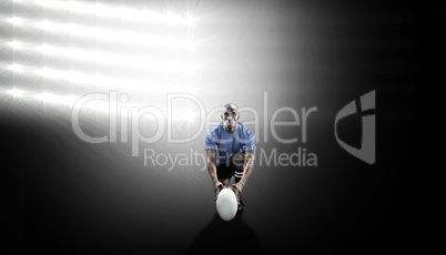 Composite image of portrait of rugby player holding ball while k