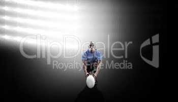 Composite image of portrait of rugby player holding ball while k