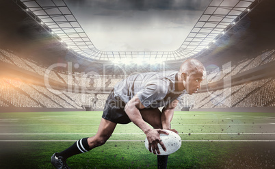 Composite image of determined athlete bending while playing rugb