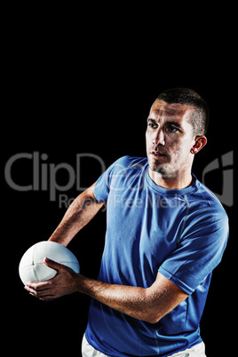 Composite image of rugby player looking away while holding ball