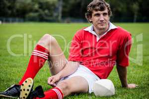 Rugby player sitting on grass before match