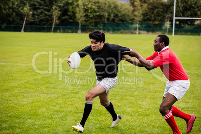 Rugby players tackling during game