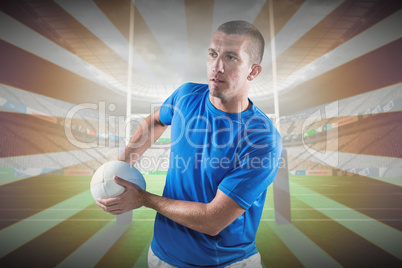 Composite image of rugby player looking away while holding ball