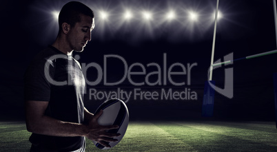 Composite image of calm rugby player thinking while holding ball