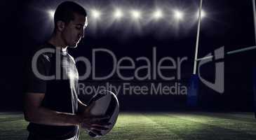 Composite image of calm rugby player thinking while holding ball