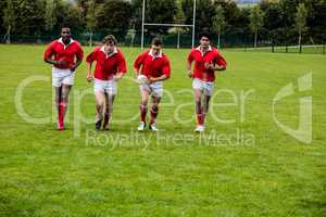 Rugby players jogging with ball