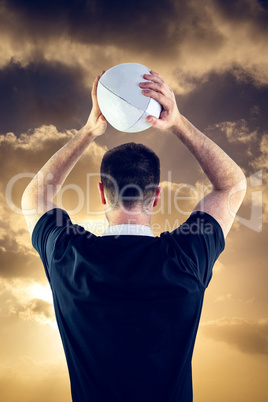 Composite image of rugby player about to throw a rugby ball