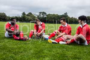 Rugby players sitting on grass before match