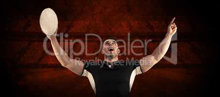 Composite image of rugby player cheering with the ball