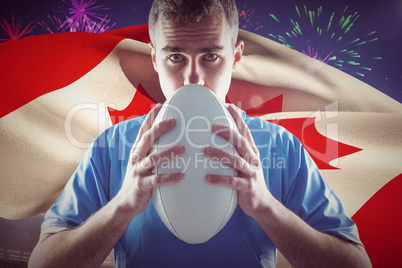 Composite image of rugby player holding a rugby ball