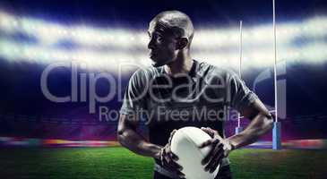 Composite image of determined rugby player holding ball