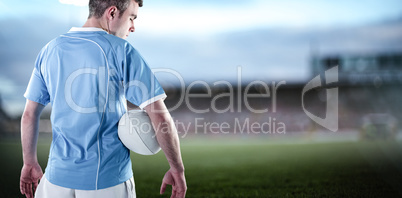 Composite image of rugby player holding a rugby ball