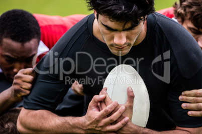 Rugby players tackling during game