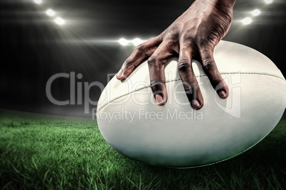 Composite image of cropped image of sportsman holding rugby ball