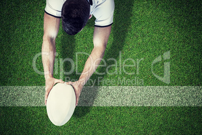 Composite image of high angle view of man holding rugby ball wit