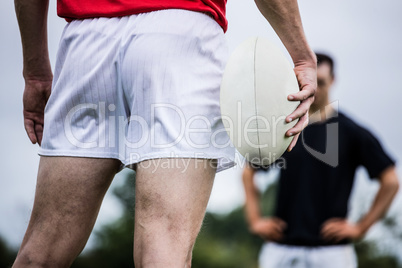 Rugby player standing with ball