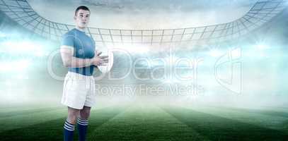 Composite image of rugby player holding rugby ball