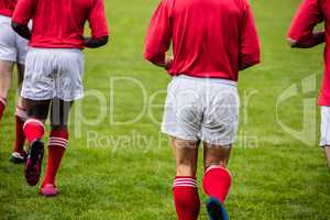 Rugby players jogging with ball