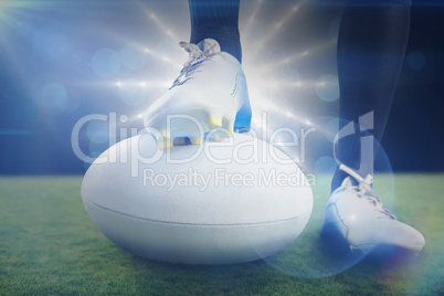 Composite image of rugby player posing feet on the ball