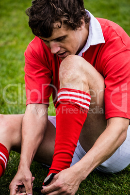 Rugby player sitting on grass