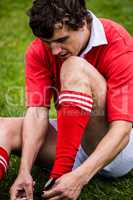 Rugby player sitting on grass