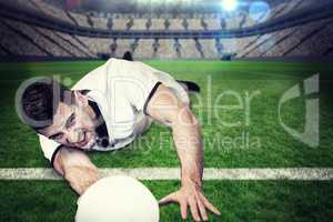 Composite image of man lying down while holding ball