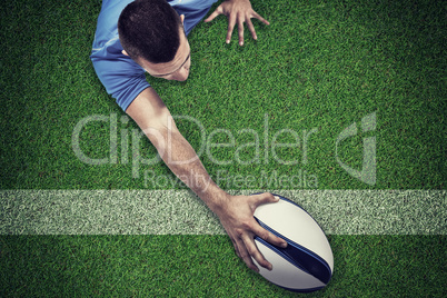 Composite image of rear view of rugby player lying in front with
