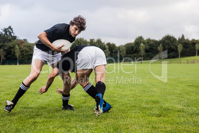 Rugby players tackling during game