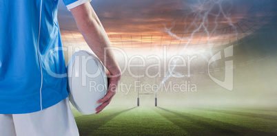 Composite image of serious rugby player with arms crossed