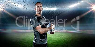 Composite image of confident rugby player in holding ball