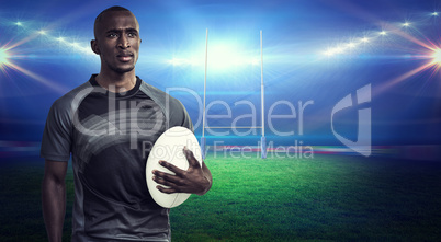 Composite image of thoughtful athlete holding rugby ball