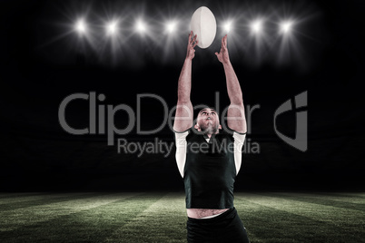 Composite image of rugby player catching the ball