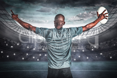 Composite image of rear view of athlete with arms raised holding