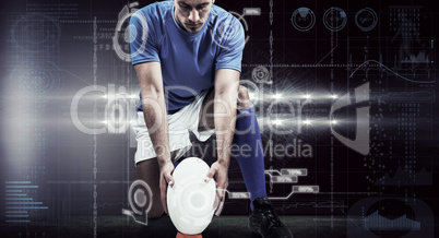 Composite image of full length of rugby player placing ball